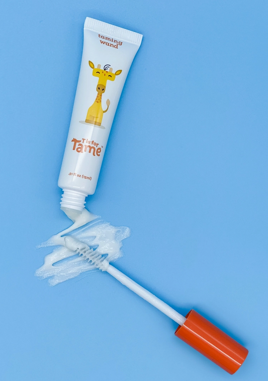 The taming wand squeezed onto its brush applicator against a blue ground