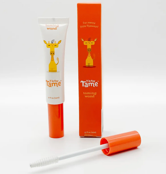 White taming wand tube printed with a giraffe, beside its orange box and the brush applicator
